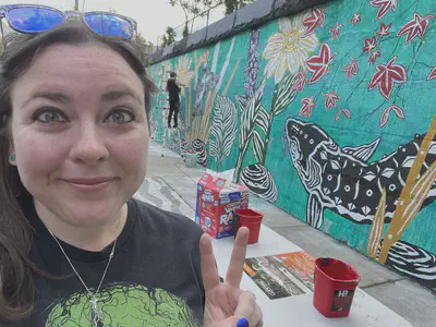 Dr. McAnulty taking a selfie with an in-progress mural. Photo by Dr. Sarah McAnulty.