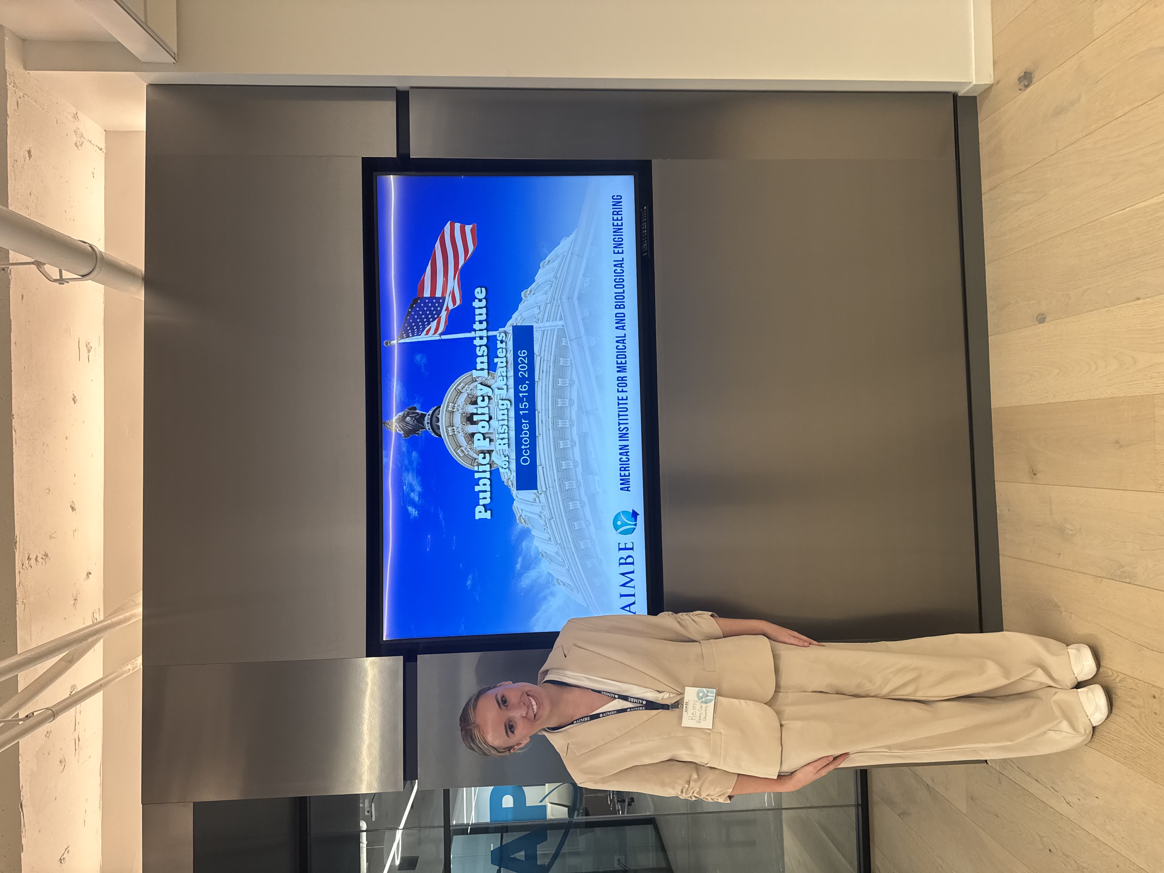Remy Carlson beside the Public Policy Institute for Rising Leaders display
